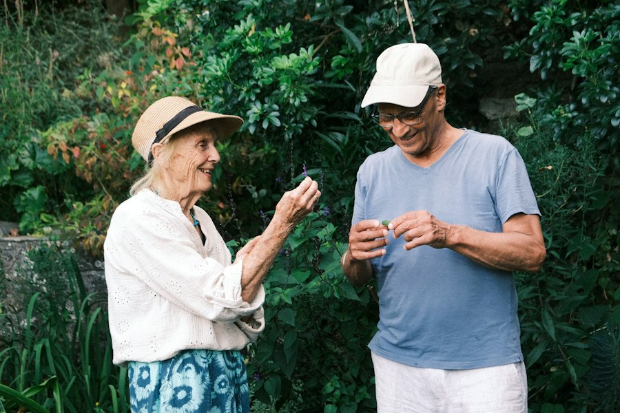 Un couple de seniors souriants dans leur jardin