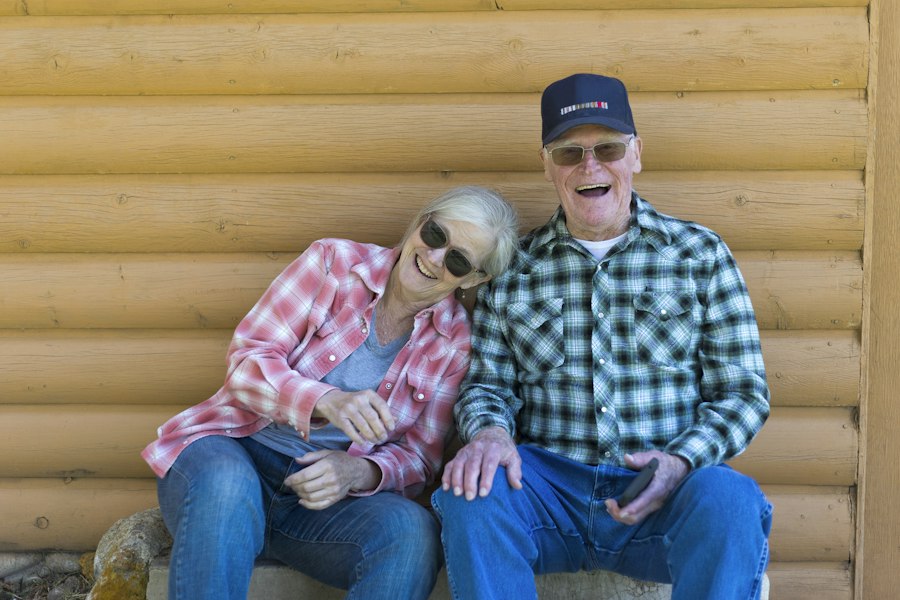 Un couple de seniors qui rit, assis côte à côte