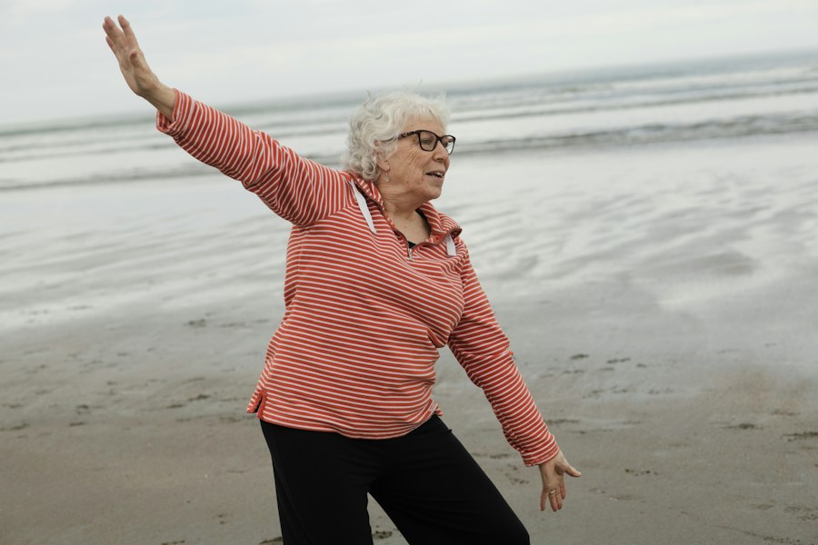Une femme âgée fait des mouvements d'assouplissement sur la plage